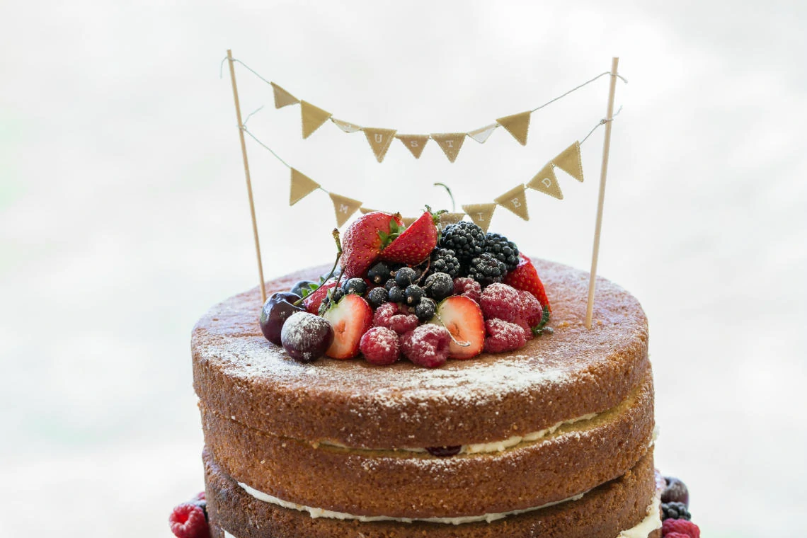 detail shot of naked wedding cake with fruit topping
