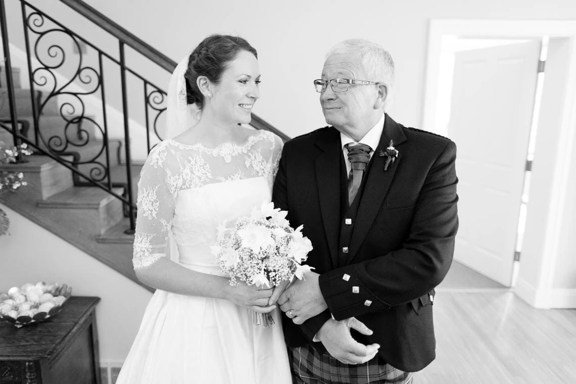 bride and her father at the bottom of the stairs in Dunglass House