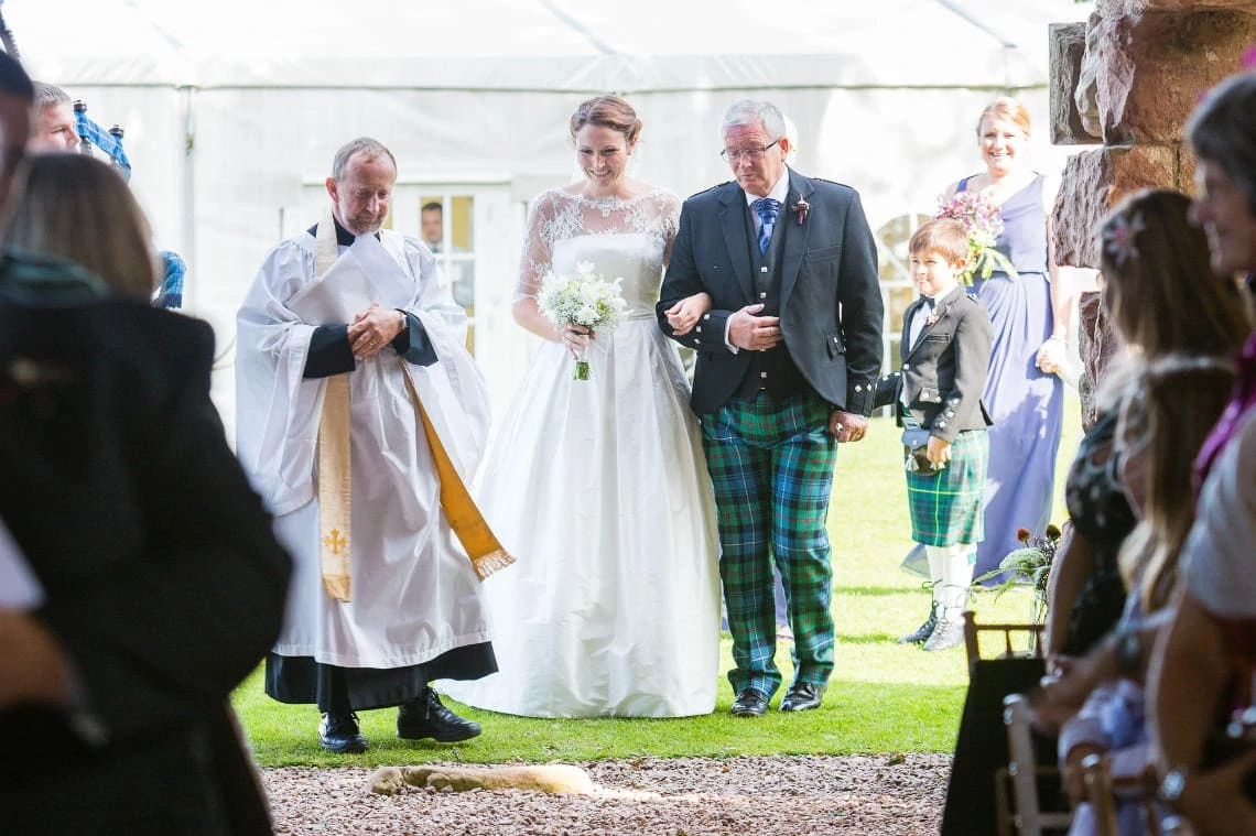 bride, her father and the Reverend enter Dunglass Church for the processional