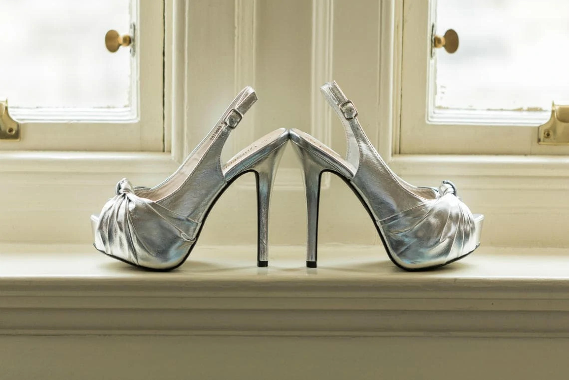 bride's high-heeled silver shoes