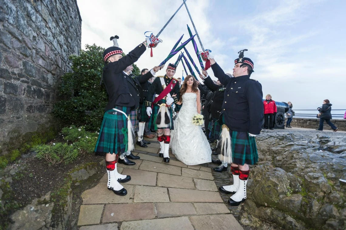 Edinburgh Castle wedding photos: bride and groom walking though the guard of honour outside St Margaret's Chapel