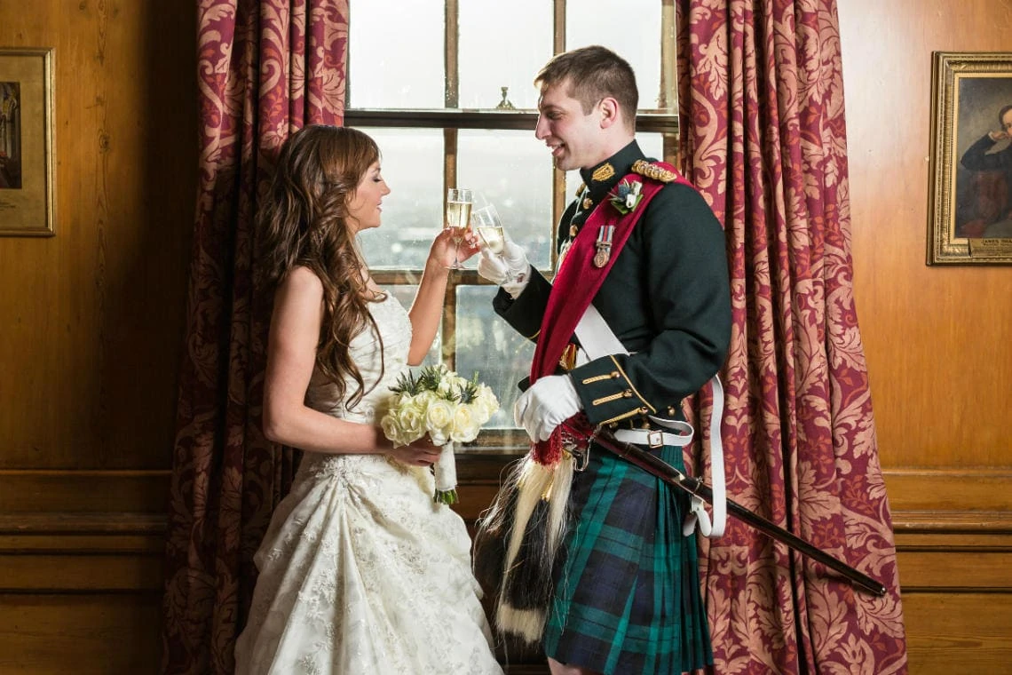 bride and groom raise a toast in the Officer's Mess at Edinburgh Castle