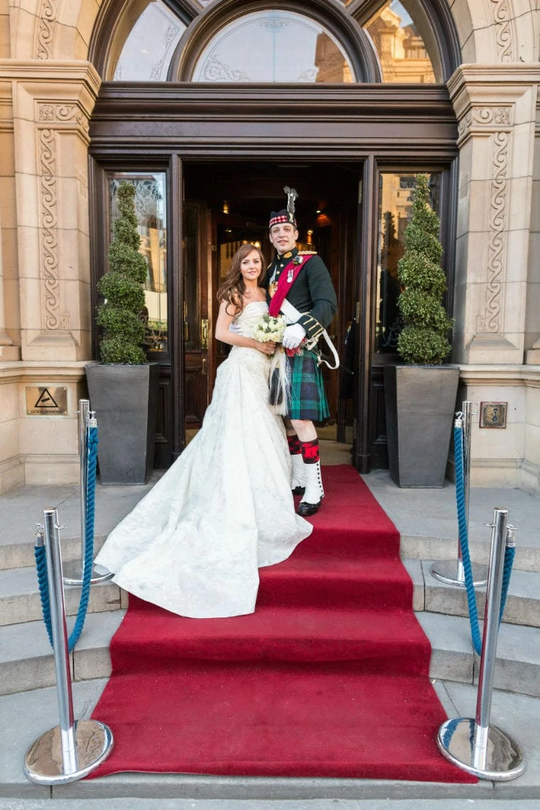 bride and groom on the red carpet at the entrance to the Balmoral Hotel