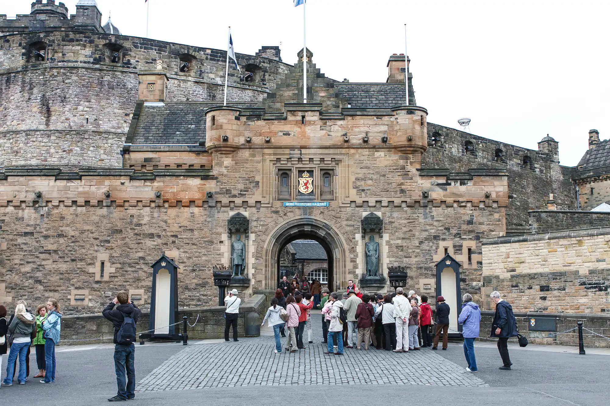 Tourists gather in front of the entrance to edinburgh castle, a historic fortress located in edinburgh, scotland.