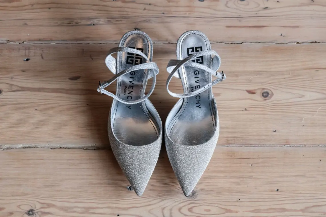 Elevated photo of silver Givenchy high heeled shoes on wooden floor