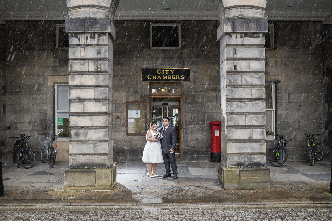 newlyweds standing at the entrance in driving sleet