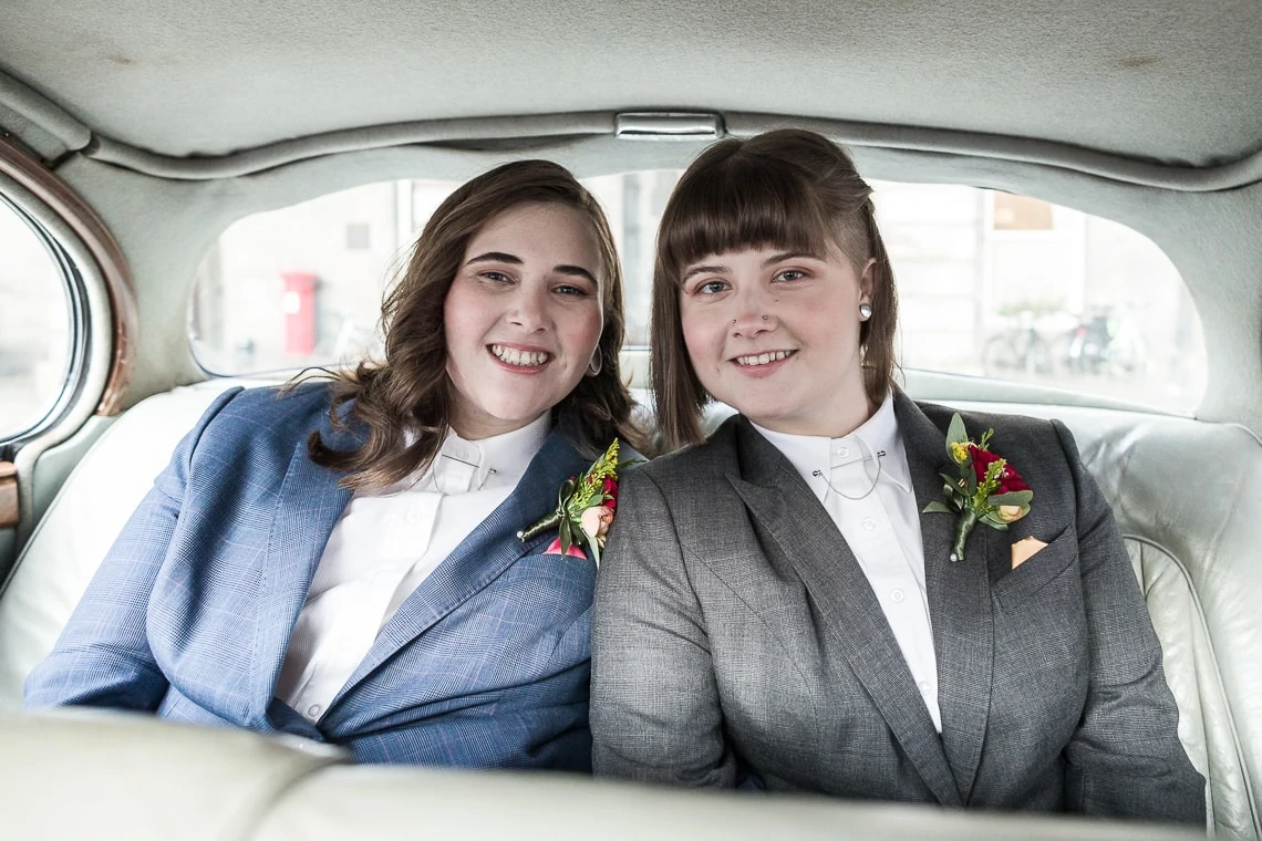 newly-wed same-sex couple in wedding car