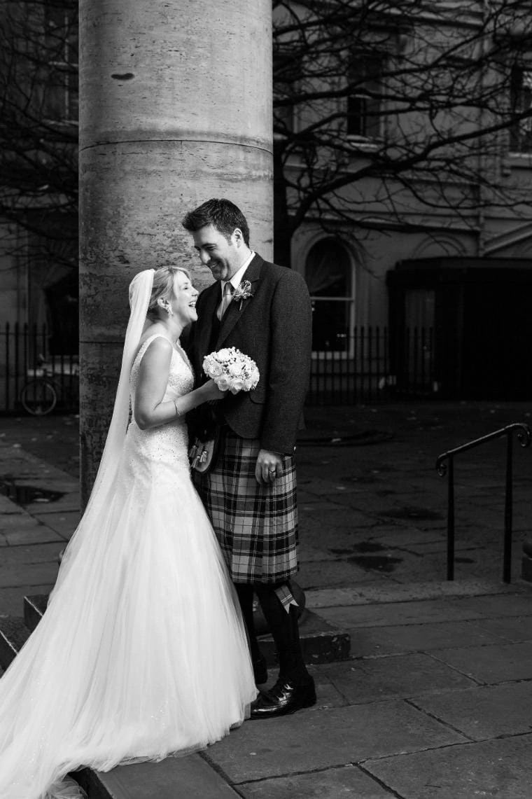 newly-weds black and white standing next to pillar on George Street