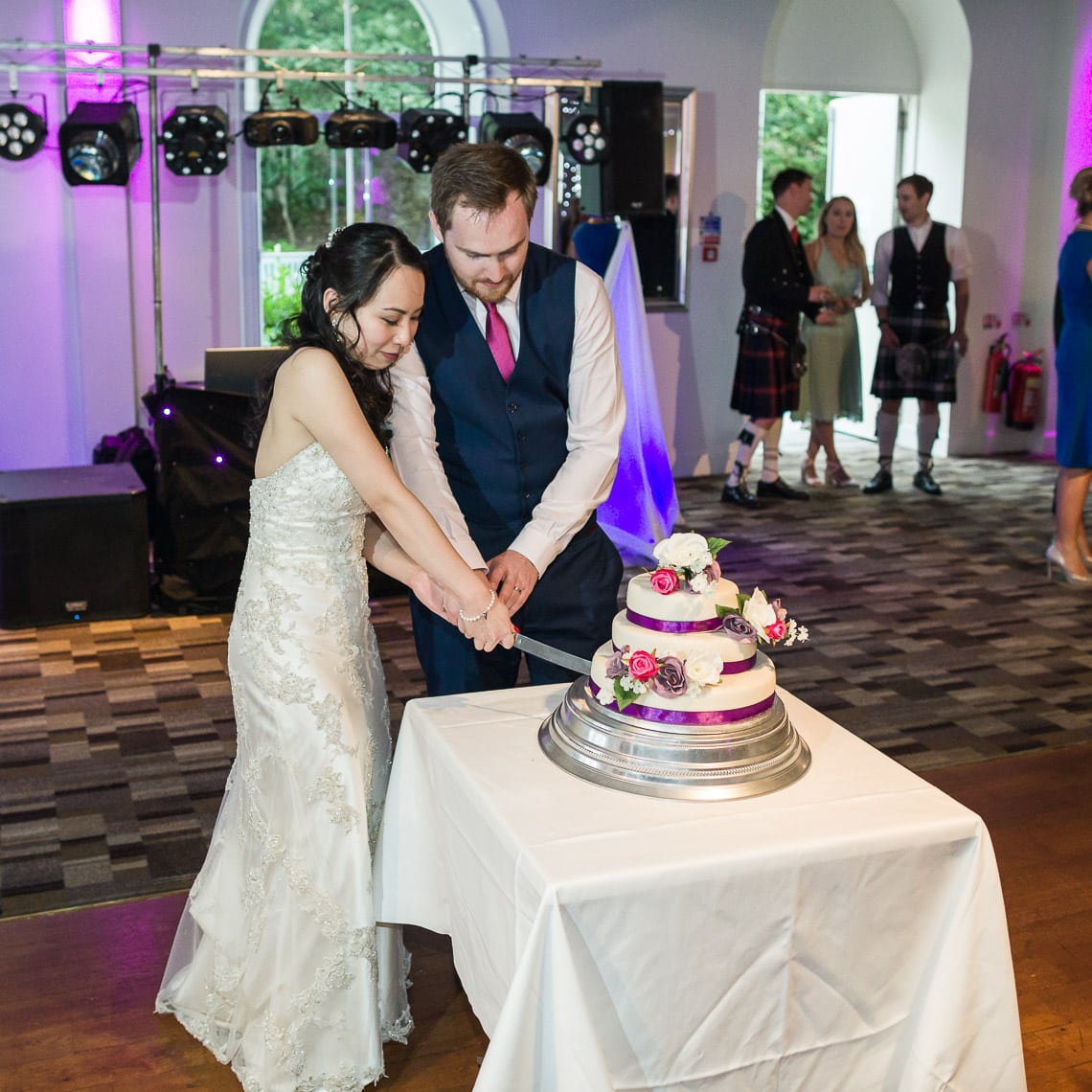 Newlyweds cut their wedding cake on the dancefloor.