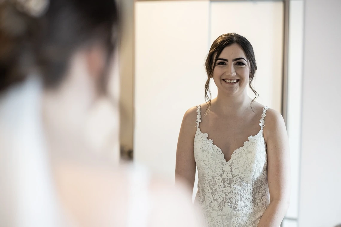 bride looking in a mirror wearing Rosa Clara dress