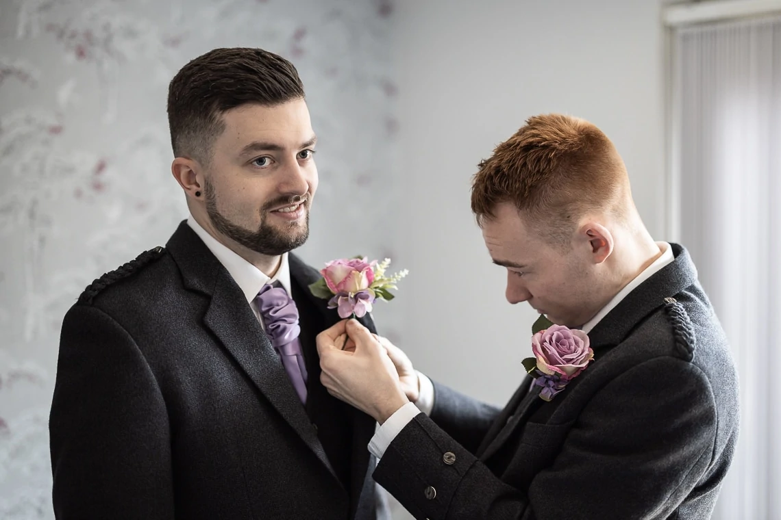 groomsman and groom fitting buttonhole by Annie Thompson Flowers