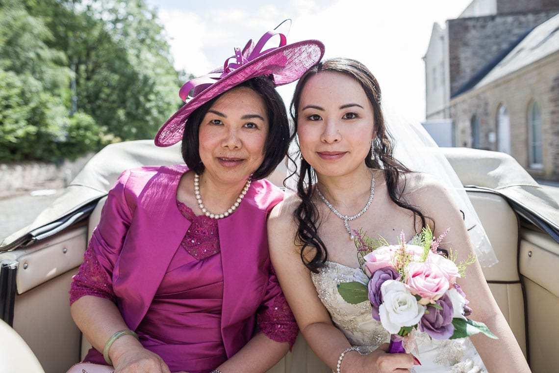 posed photo of mother of the bride with bride in wedding car