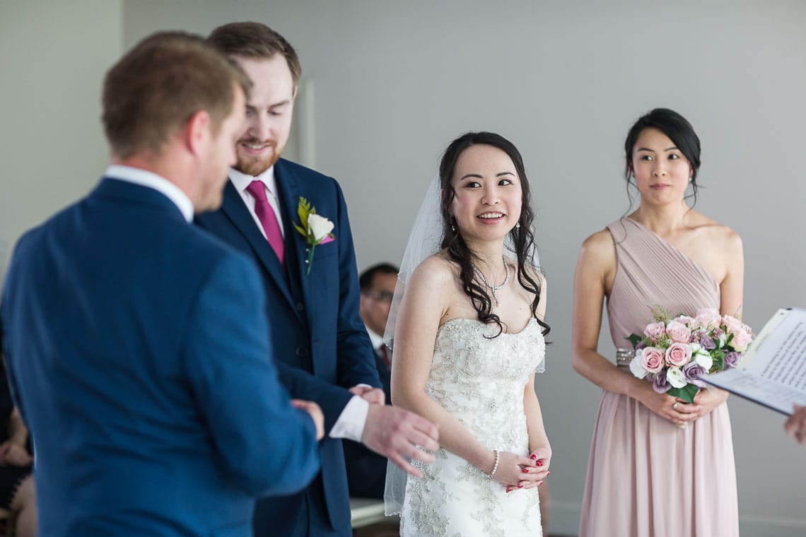 bride smiling at bestman during wedding ceremony