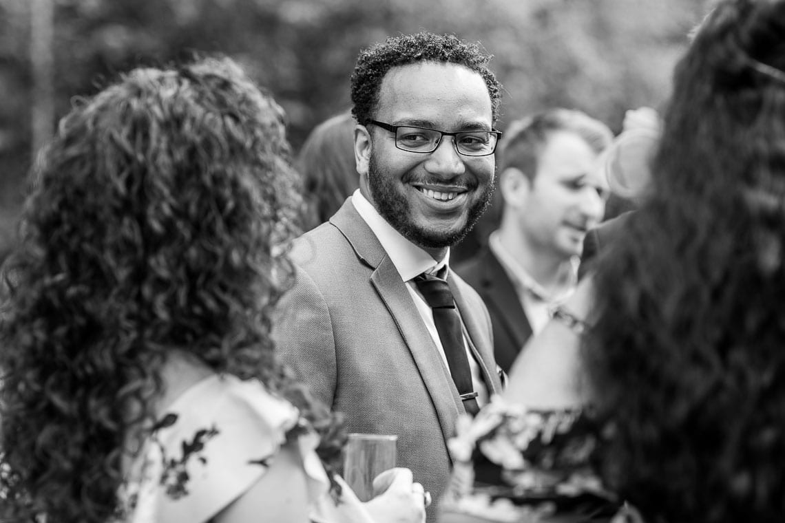 male guest smiling at outdoor drinks reception