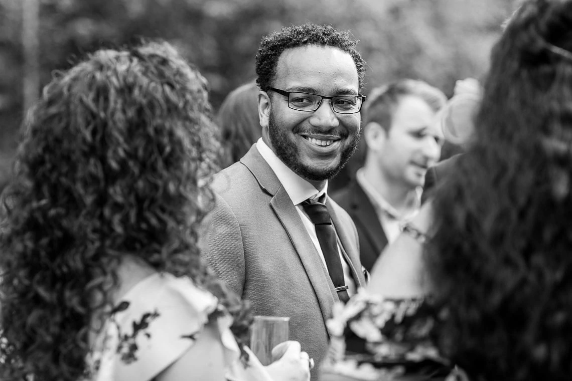 male guest smiling at outdoor drinks reception