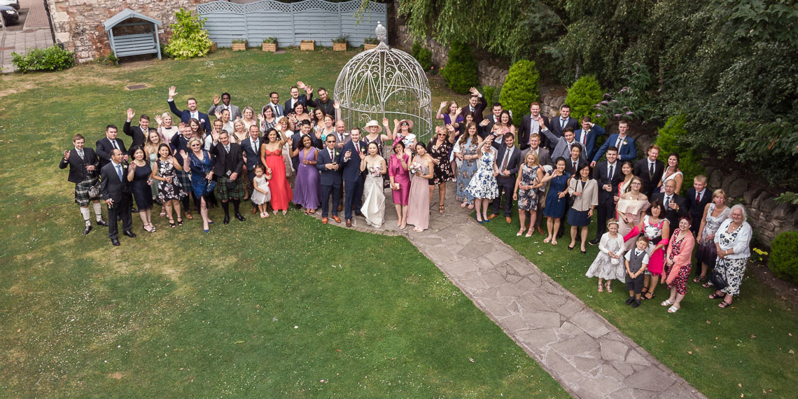 overhead group photo of wedding party in garden taken by drone