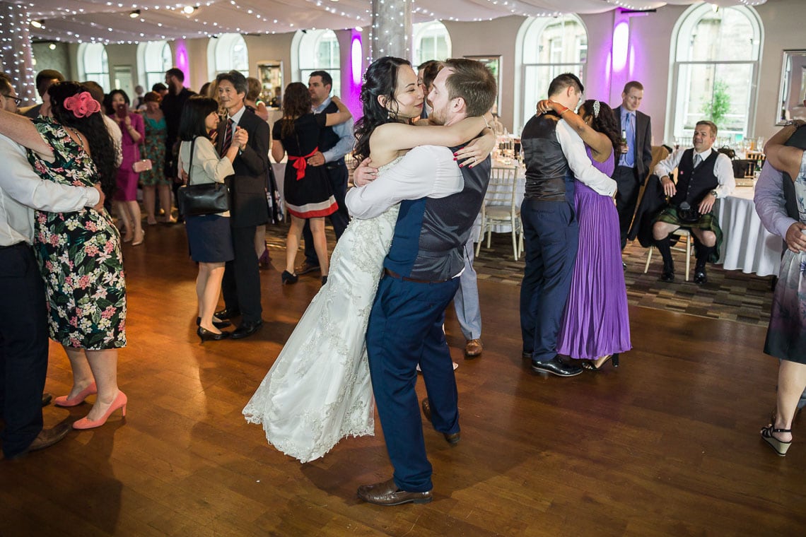 Eskmills Venue wedding groom lifting up bride on dancefloor during first dance at evening reception