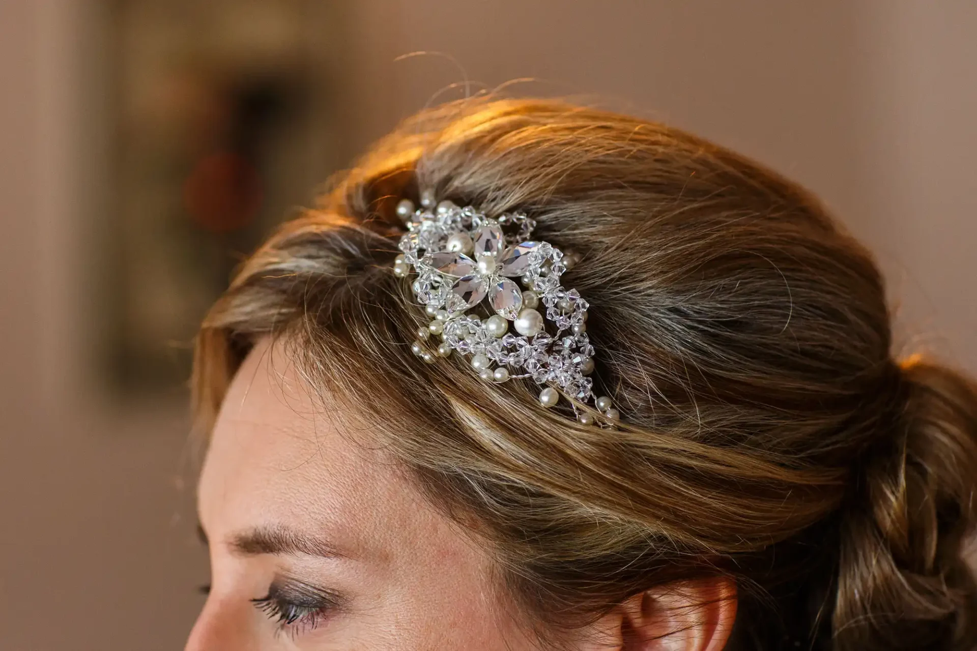 Close-up of a woman's hairstyle adorned with an intricate, jewel-encrusted hair accessory.