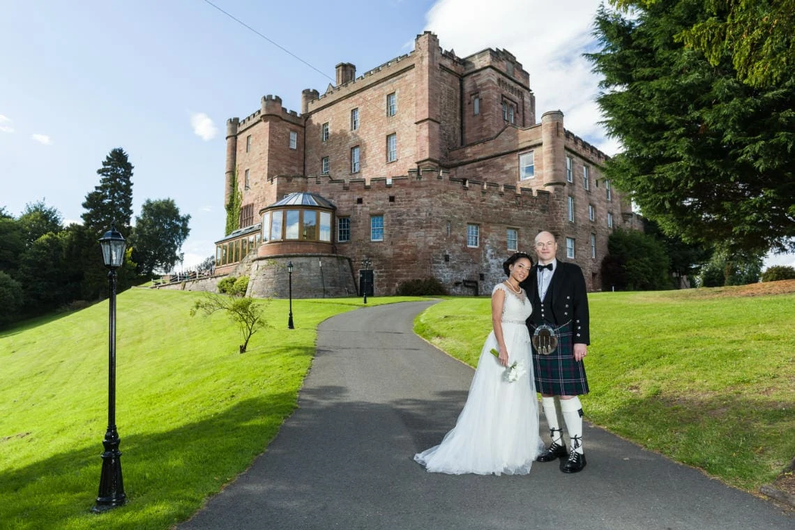 Gardens - bride and groom with castle in the background