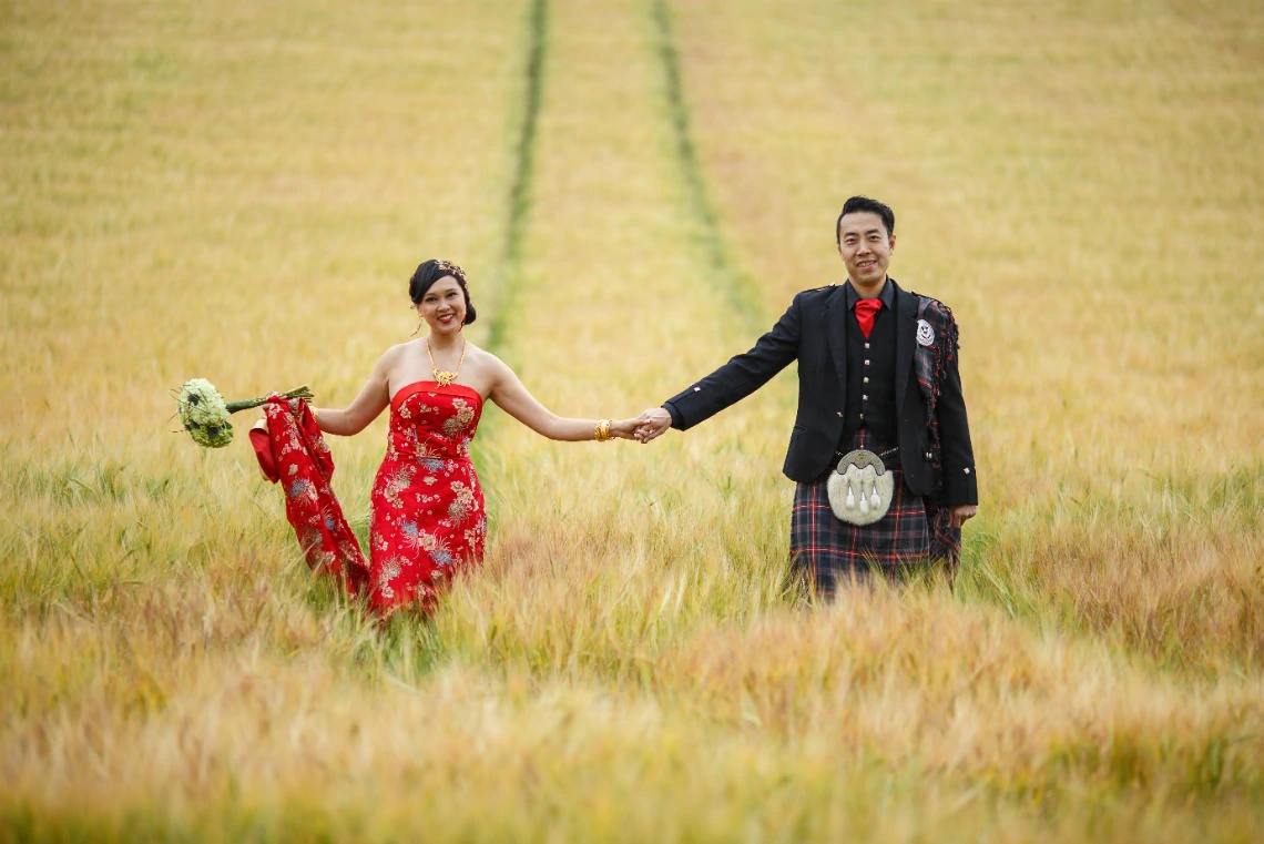 Gardens - newlyweds holding hands in the field