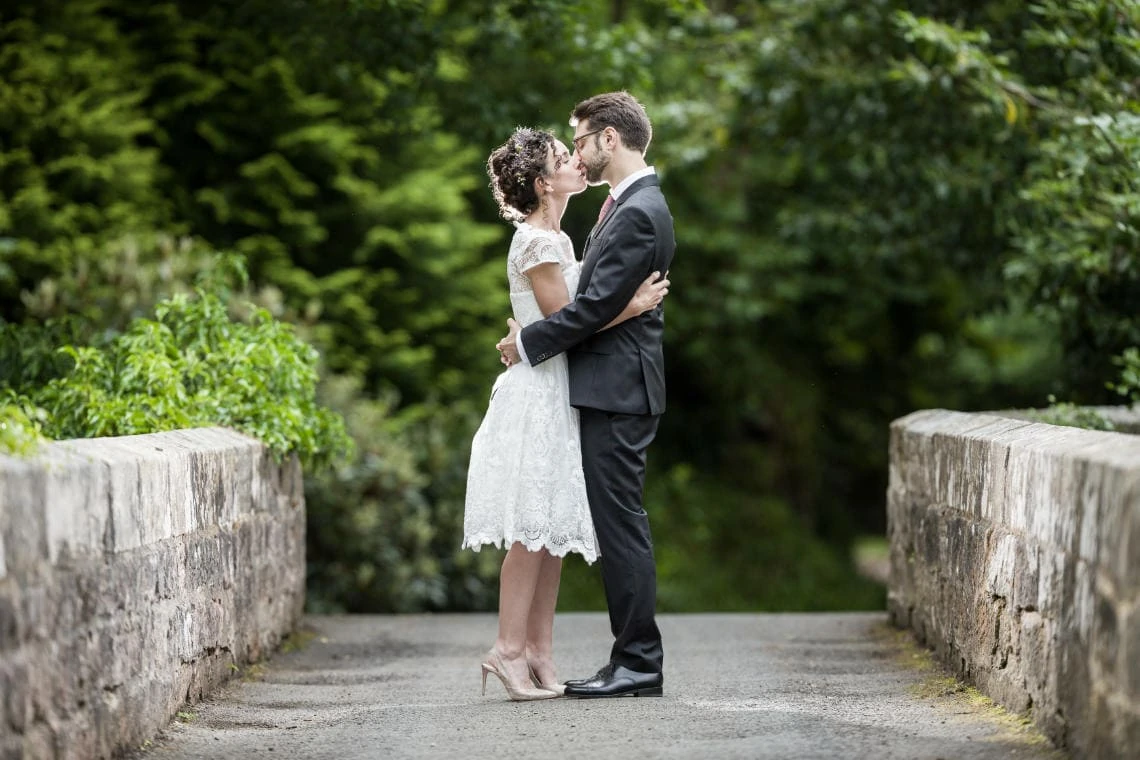 Gardens - newlyweds kissing on the arched bridge