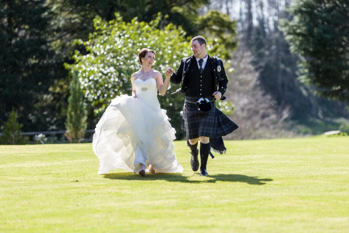 Gardens - newlyweds running across the lawn laughing