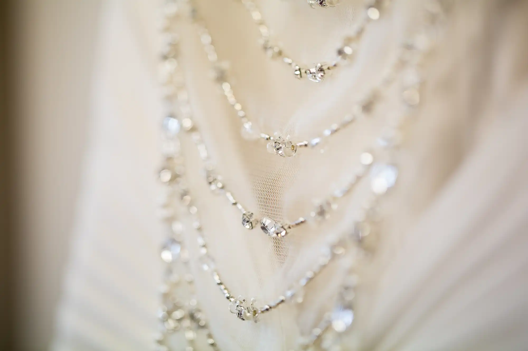 Close-up of a white fabric adorned with sparkling crystal beads.