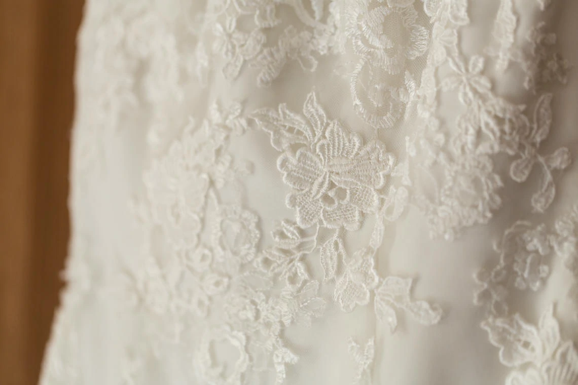 macro detail photo of lace details on white wedding dress