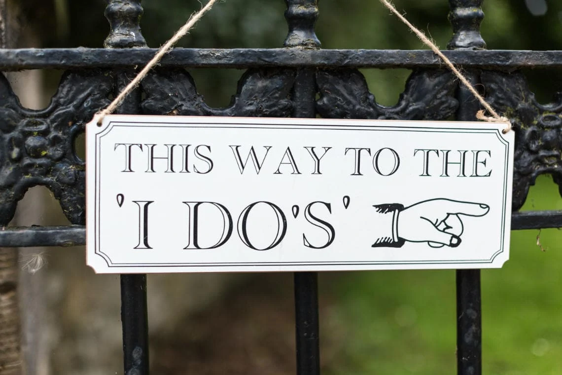 This way to the 'I do's' sign on gate of the church