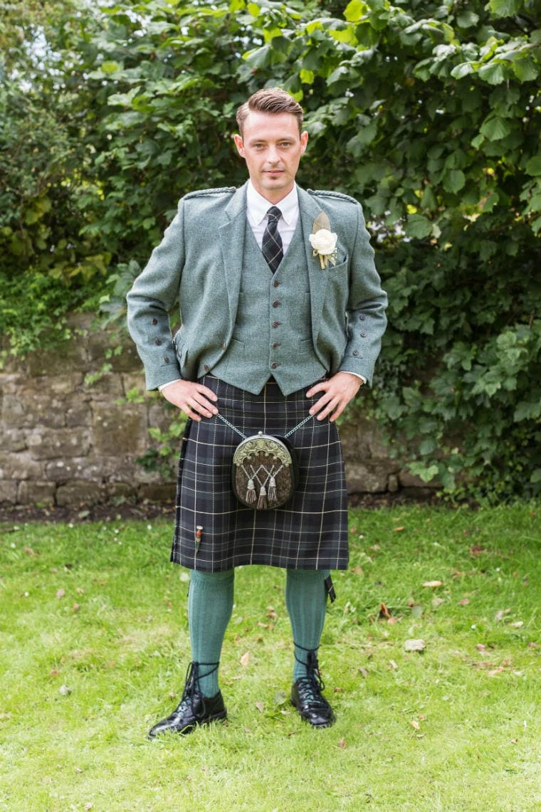 groom wearing a Highland kilt outfit with green tweed and blue kilt and tie