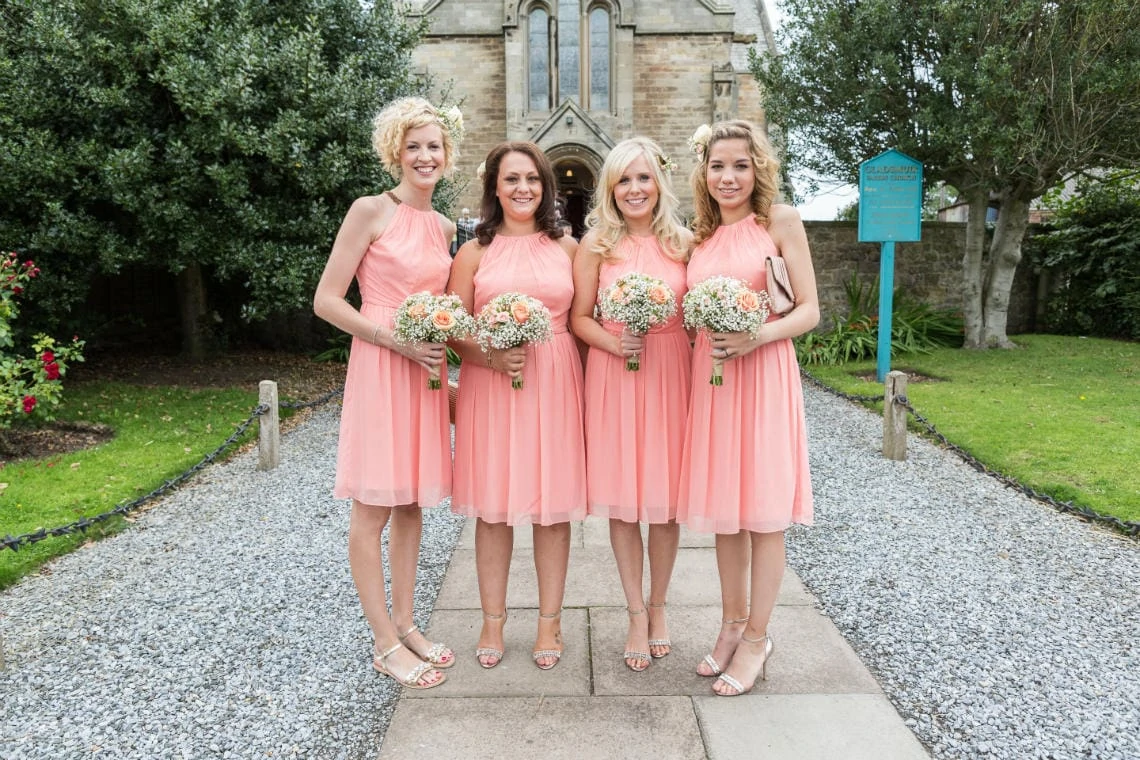 bridesmaids wearing peach dresses outside the church in East Lothian