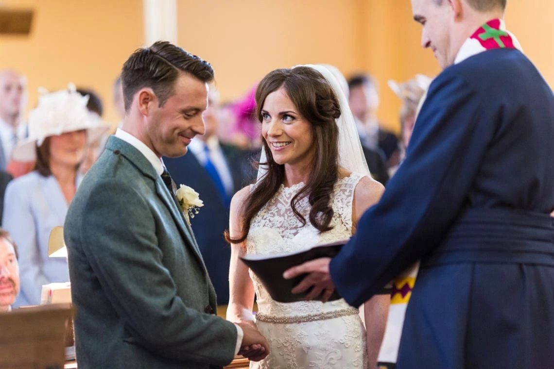 smiling bride and groom during the exchange of marriage vows at the church in East Lothian