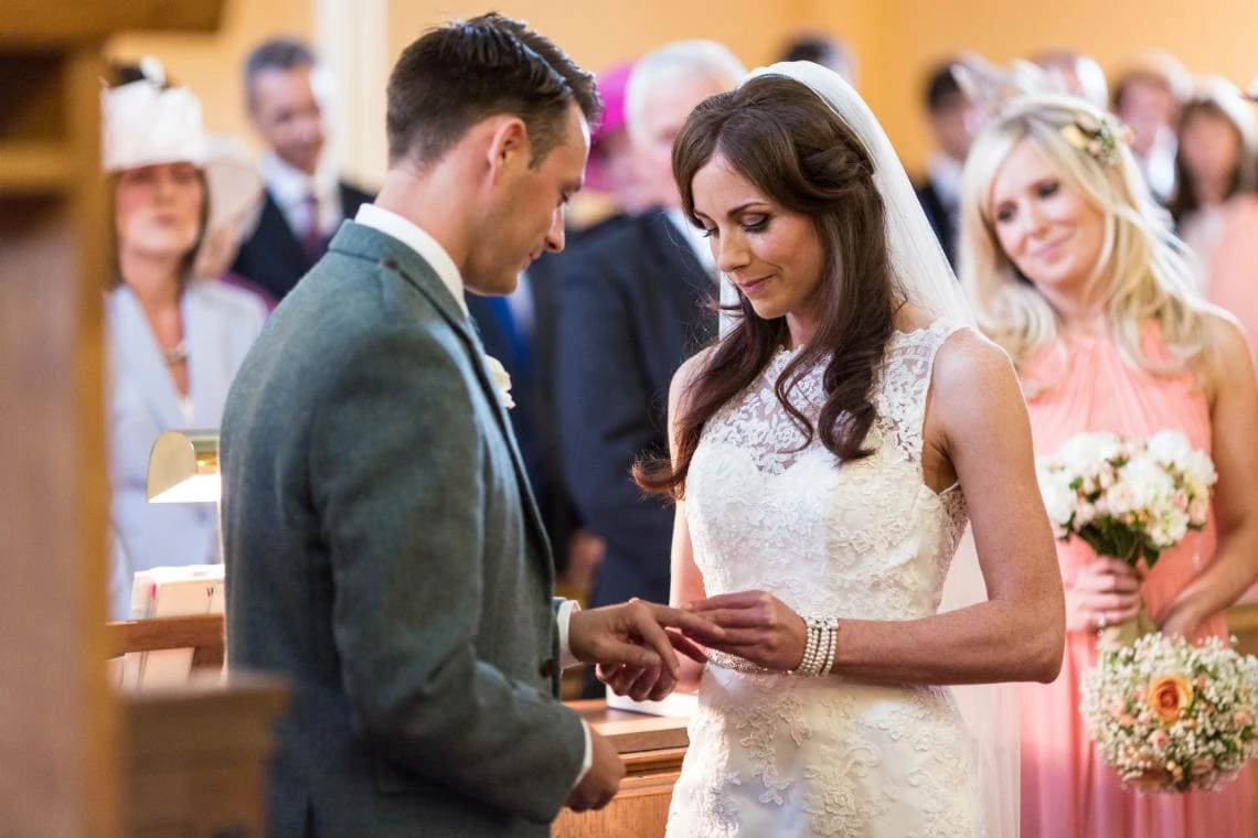 bride places the ring on her groom during ceremony at the church in East Lothian
