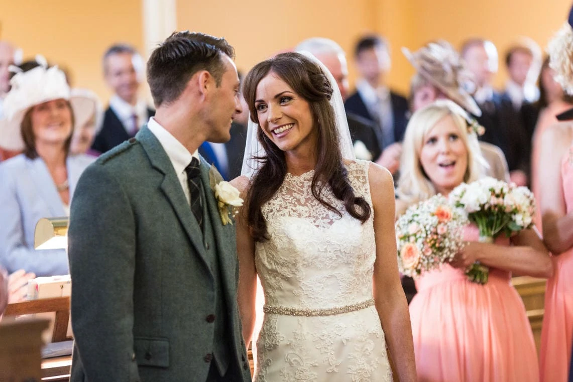 newlyweds smiling at each other as they are announced as the new Mr and Mrs at the church at Gladsmuir