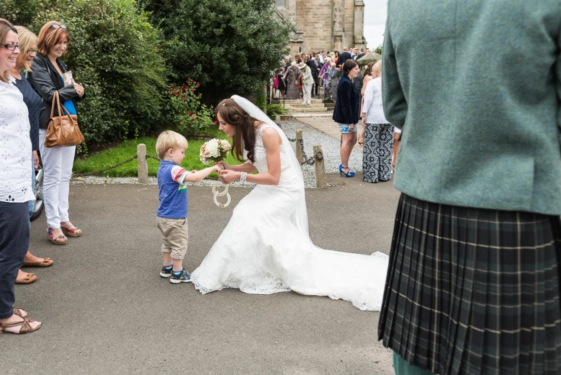 little boy presents good luck horseshoes to the bride outside at the church in East Lothian