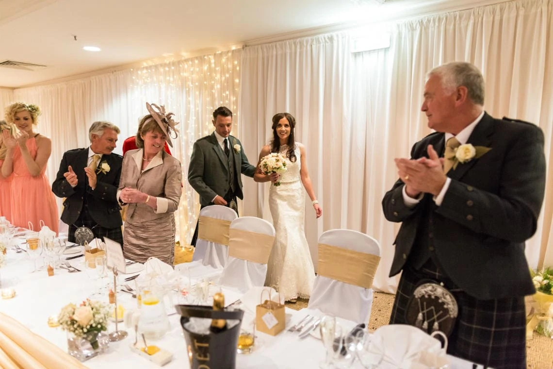top table guests congratulate the newlyweds in the Dalmahoy Suite