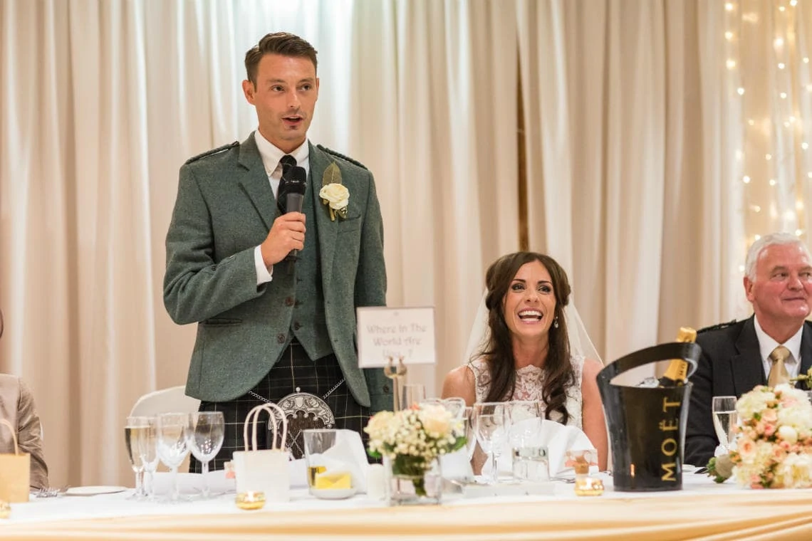 bride laughing during the groom's speech in the Dalmahoy Suite