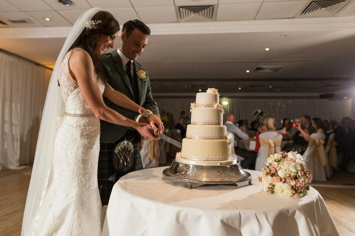 newlyweds cutting the cake in the Dalmahoy Suite