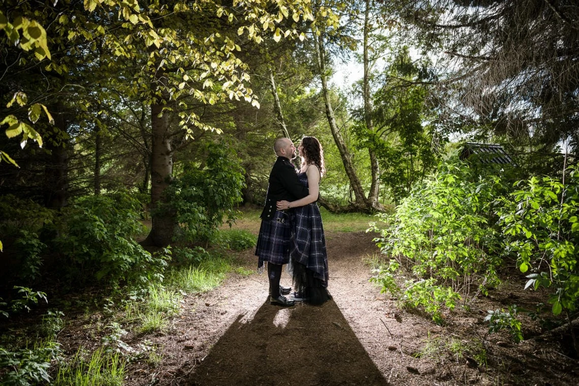 Golf course and grounds - newlyweds embrace in the woodland