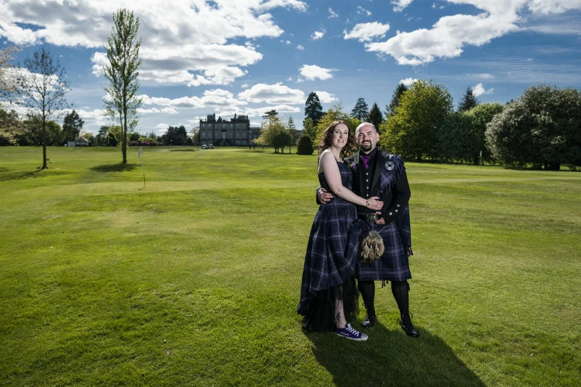 Golf course and grounds - newlyweds embrace wide angle photo