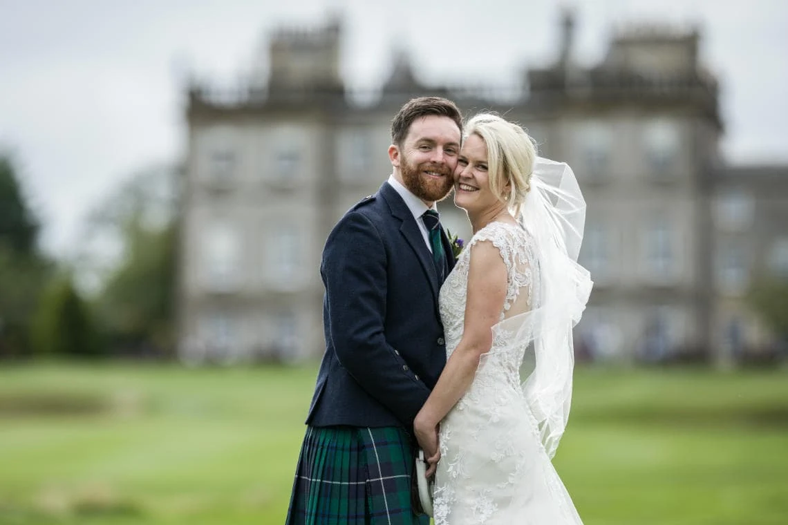 Golf course and grounds - newlyweds embrace with hotel backdrop