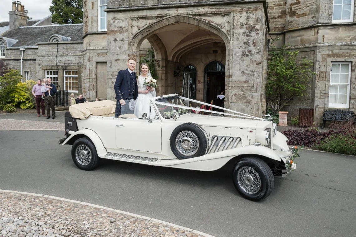 Golf course and grounds - newlyweds in classic car at the entrance