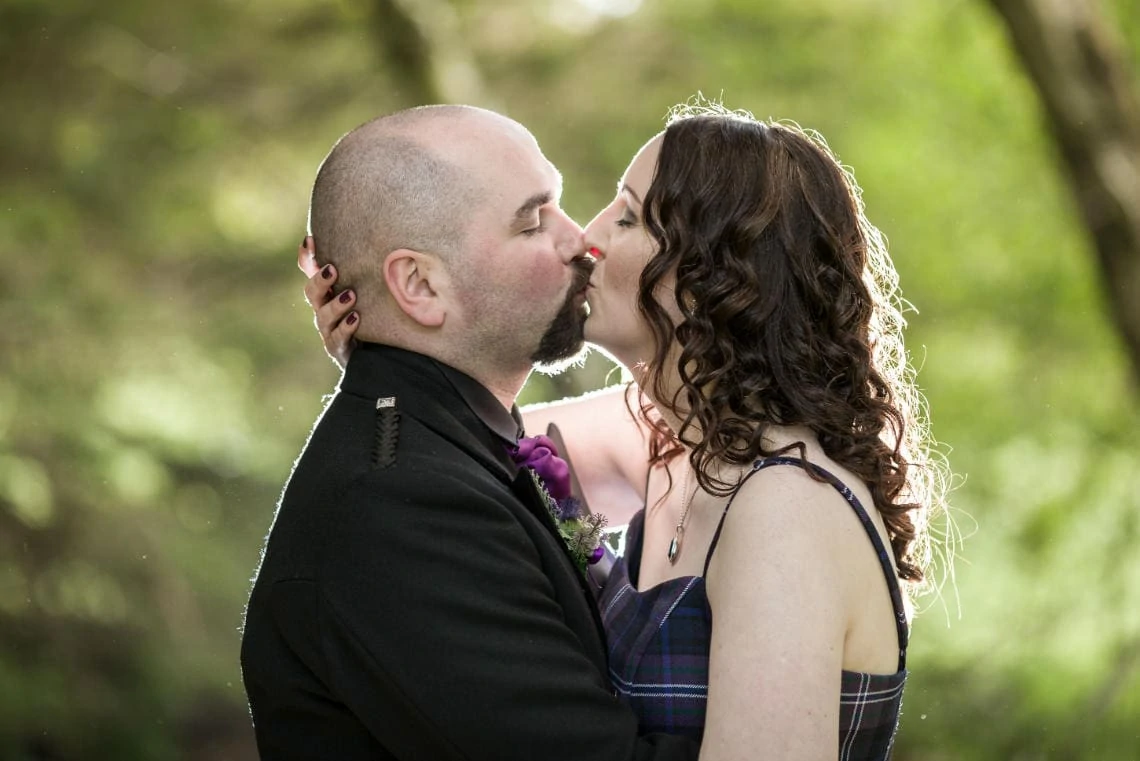 Golf course and grounds - newlyweds kissing in the woodland