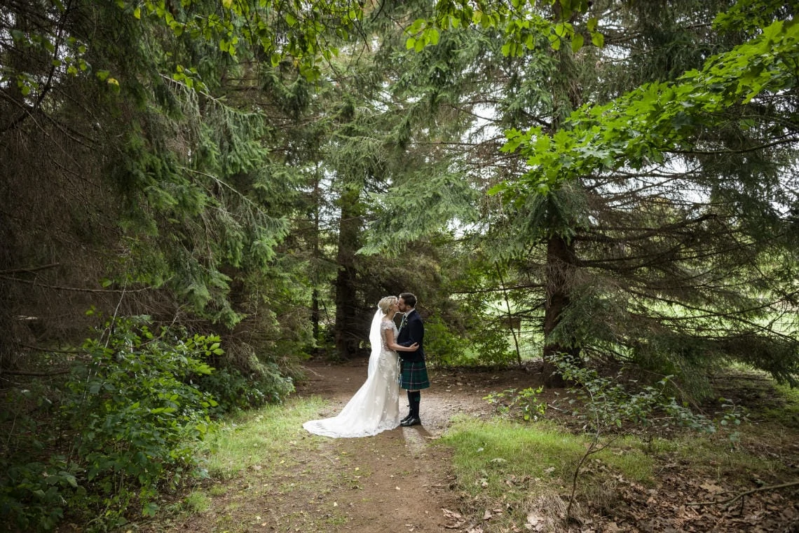 Golf course and grounds - newlyweds kissing in the woods
