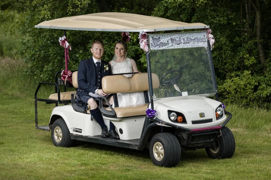 Golf course and grounds - newlyweds sitting in the golf cart