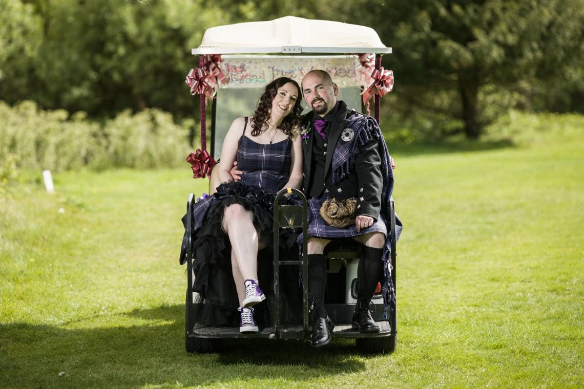 Golf course and grounds - newlyweds sitting on the back of the golf cart