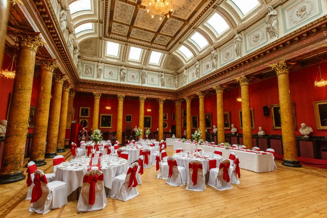 Great Hall prepared for wedding breakfast with red and white colour scheme