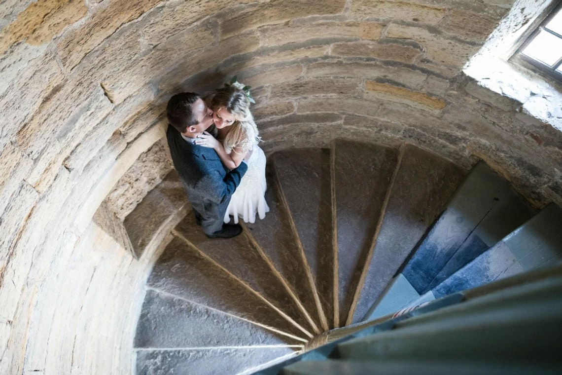 Newlyweds embrace on the spiral staircase of Inchcolm Abbey