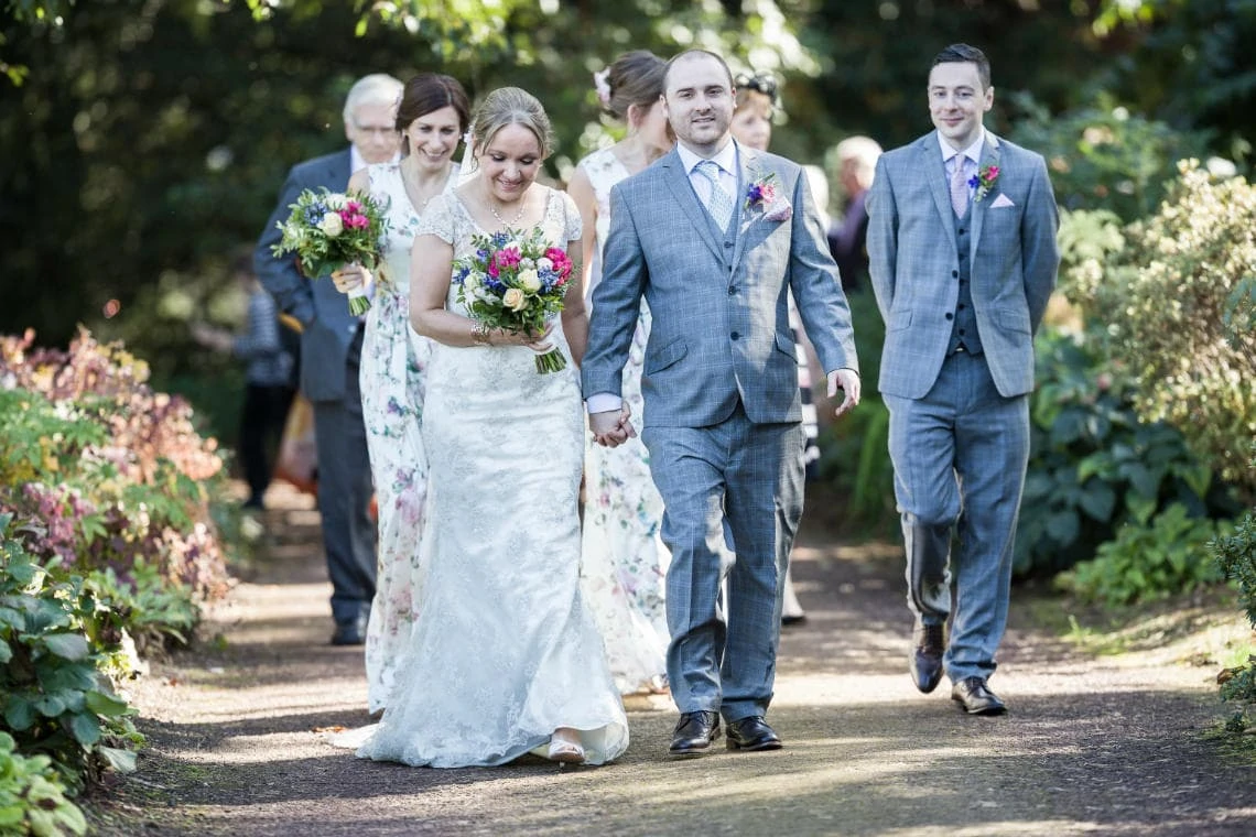 John Muir Grove newlyweds and wedding party walking to Caledonian Hall