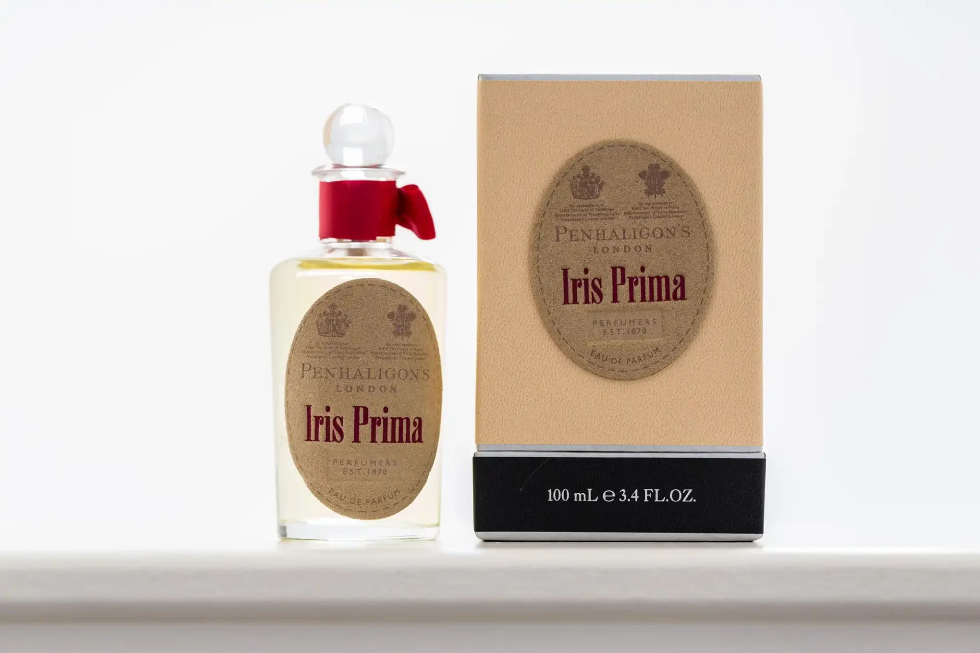 Penhaligon's iris prima perfume bottle next to its box on a white surface.